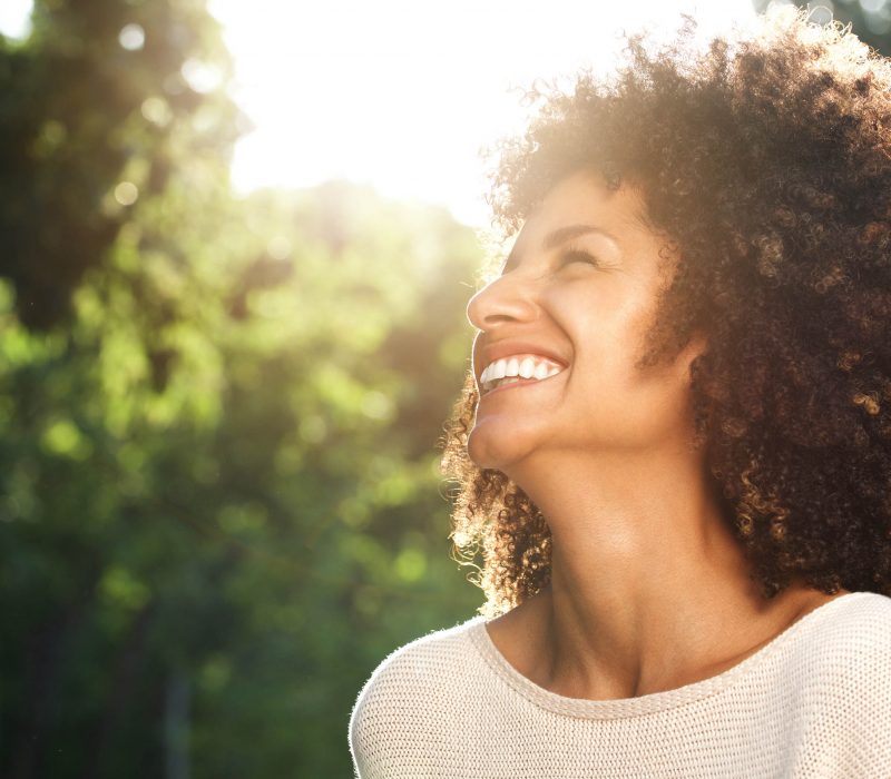 Close up portrait of beautiful confident woman laughing in nature