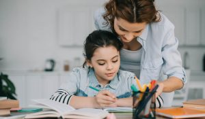 mom helping her child with best-guess spelling and homework at home