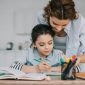 mom helping her child with best-guess spelling and homework at home